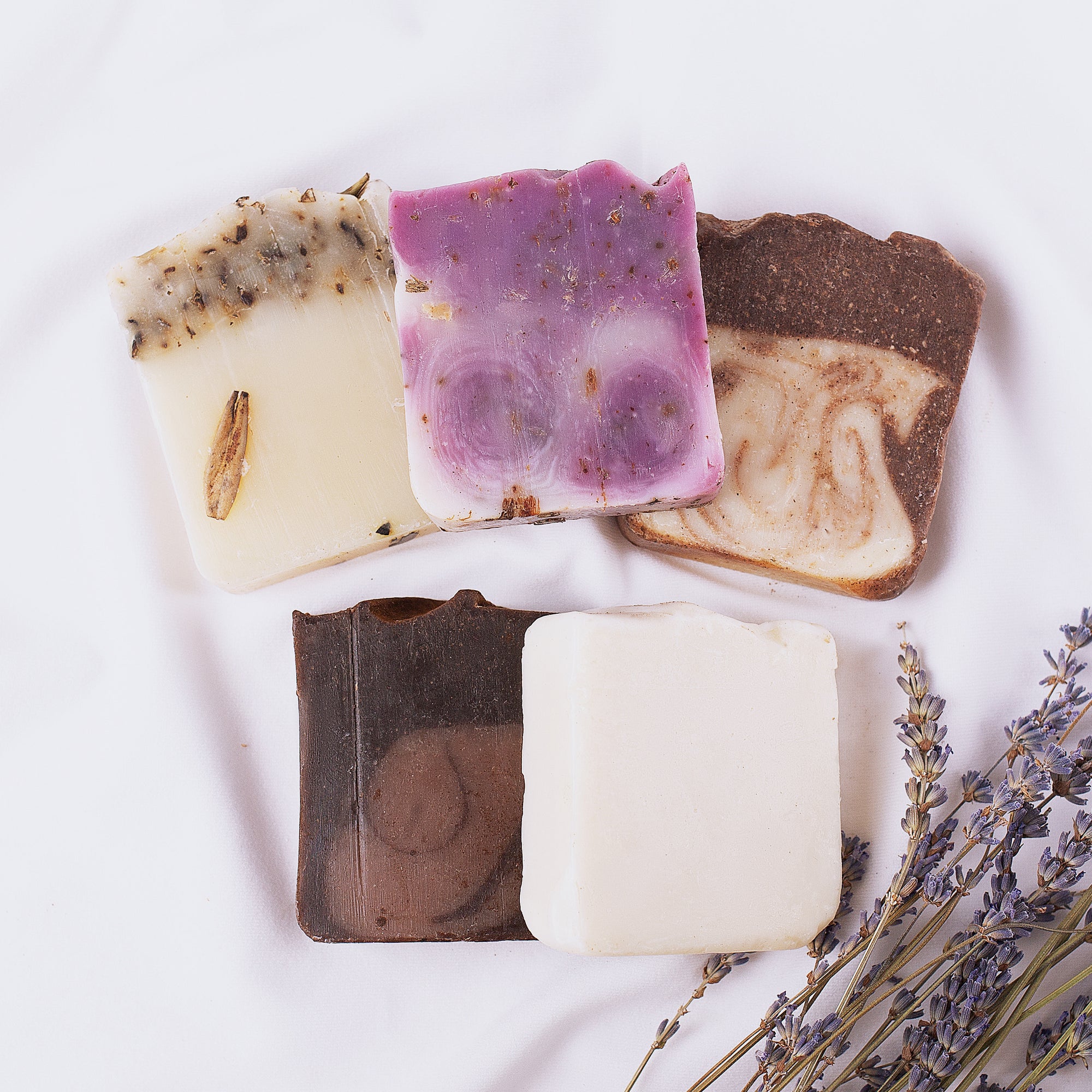 handmade soaps collection on soft silk cloth next to lavender plants - Handmade Soaps Collection - PFAS Free Soaps