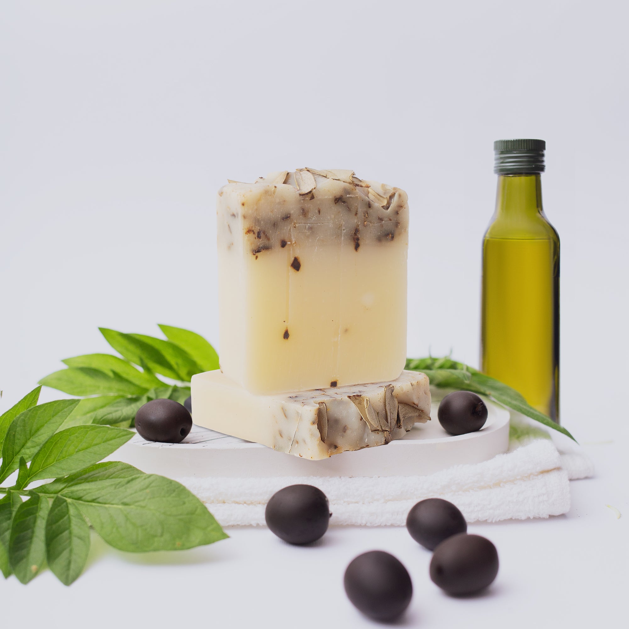 Olive Oil Soap - Lifestyle next to olive oil bottle and black olives - PFAS Free Soaps